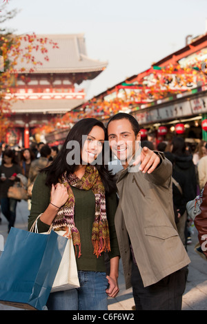 L'homme et de la femme shopping ensemble soulignant les nouvelles boutiques dans centre commercial extérieur. Banque D'Images