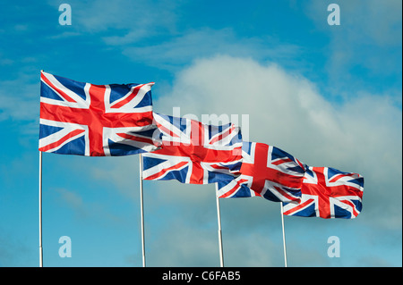 Quatre drapeaux Union Jack flottant au vent contre un ciel bleu Banque D'Images