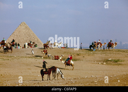 La petite pyramide de Mykérinos, partie des trois pyramides dans le complexe de grandes pyramides de Gizeh, avec les touristes chameaux Banque D'Images