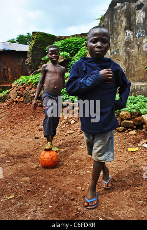 Les enfants jouent au football dans un quartier pauvre de Freetown, Sierra Leone, Afrique de l'Ouest Banque D'Images