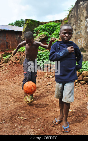 Les enfants jouent au football dans un quartier pauvre de Freetown, Sierra Leone, Afrique de l'Ouest Banque D'Images