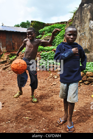 Les enfants jouent au football dans un quartier pauvre de Freetown, Sierra Leone, Afrique de l'Ouest Banque D'Images