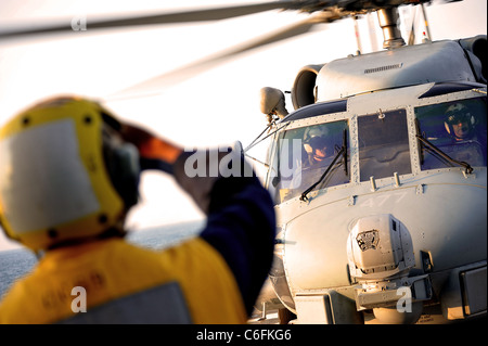 Océan Atlantique (16 août 2000 27, 2011) -- maître de Manœuvre Seaman Emmanuel Dixon signale un SH-60B Sea Hawk, joint à l'Escadron d'hélicoptères anti-sous-lumière (HSL), 42 pour l'atterrissage pendant les opérations de vol à bord du croiseur lance-missiles USS Vicksburg (CG-69). Vicksburg se prépare à répondre aux dommages causés par l'ouragan Irène si demandé. (U.S. Photo par marine Spécialiste de la communication de masse 2e classe Gary Granger Jr./libérés) Banque D'Images