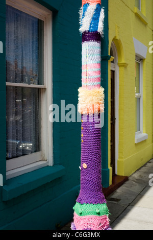 Manchon tricoté autour d'un lampadaire en face de terrasse de maisons multicolores uk angleterre southsea Banque D'Images