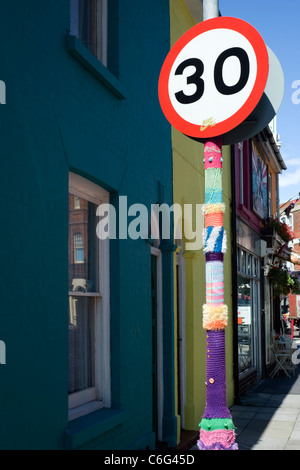 Manchon tricoté autour d'un lampadaire en face de terrasse de maisons multicolores uk angleterre southsea Banque D'Images