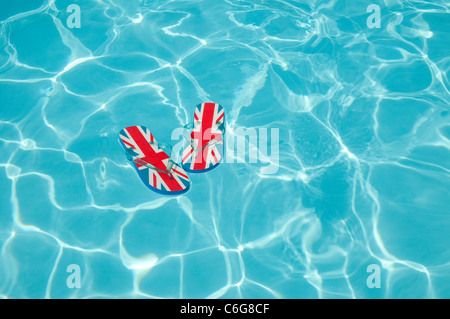Union jack tongs floating in swimming pool Banque D'Images