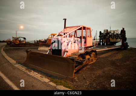 Bateau de pêche avec bulldozer sur remorque. Une plage exposée à Ngawi, Nouvelle-Zélande, où les bateaux sont sortis de l'eau lorsqu'il n'est pas Banque D'Images