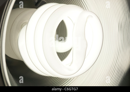 Ampoule fluorescente compacte à économie d'énergie à l'intérieur d'un rougeoyant plat rond en métal Banque D'Images