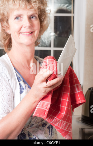 Lavage et séchage de femme à faire les tâches ménagères dans la cuisine Banque D'Images