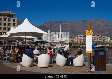 Les touristes dans un café en plein air dans le V&A Waterfront, à la lumière de la Montagne de la table Banque D'Images