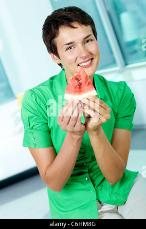 Photo de jeune femme avec morceau de pastèque looking at camera Banque D'Images