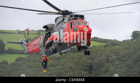 Un lifeboatman La RNLI est ramené sur un hélicoptère Sea King de la Royal Navy au cours d'un exercice pratique de sauvetage sur la rivière Dart. Banque D'Images