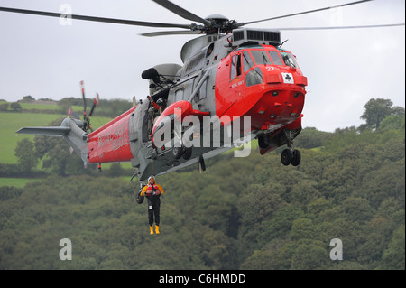 Un lifeboatman La RNLI est ramené sur un hélicoptère Sea King de la Royal Navy au cours d'un exercice pratique de sauvetage sur la rivière Dart. Banque D'Images