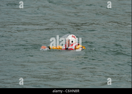 Un Lifeboatman de sauvetage de la RNLI attend par un hélicoptère Sea King de la Royal Navy pendant une simulation d'affichage de sauvetage sur la rivière Dart. Banque D'Images