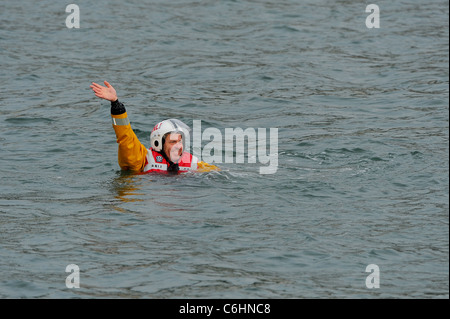 Un Lifeboatman de sauvetage de la RNLI attend par un hélicoptère Sea King de la Royal Navy pendant une simulation d'affichage de sauvetage sur la rivière Dart. Banque D'Images