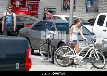 Liam Hemsworth, Billy Ray Cyrus et Miley Cyrus Miley Cyrus rides son vélo avec son petit ami et 'la dernière chanson' co-star pour Banque D'Images