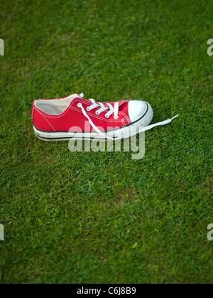 Chaussures de baseball rouge lumineux sur une pelouse verte. Banque D'Images