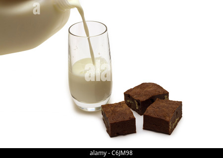 Un grand verre de lait avec des brownies fait maison sur un fond blanc Banque D'Images