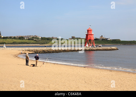 Deux hommes de pêche sable troupeau ou Littlehaven beach, phare en arrière-plan à l'épi de South Shields, North East England, UK Banque D'Images