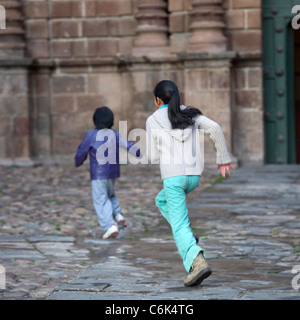Deux enfants jouant, Plaza de Armas, Cuzco, Pérou Banque D'Images