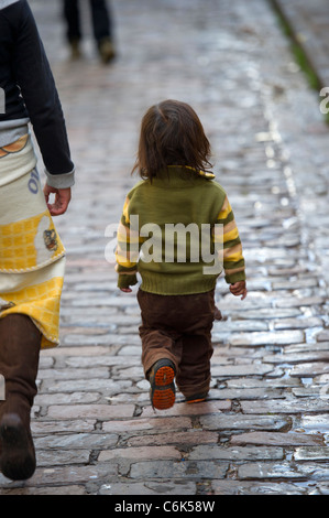 La marche de l'enfant avec la mère sur une allée pavée, Cuzco, Pérou Banque D'Images