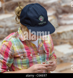 Girl holding une pierre de sel, Maras, Salinas, Vallée Sacrée, région de Cuzco, Pérou Banque D'Images