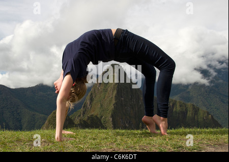 Teenage girl doing posent avec roue valley dans l'arrière-plan, la ville perdue des incas, Machu picchu, Cusco, Pérou région Banque D'Images