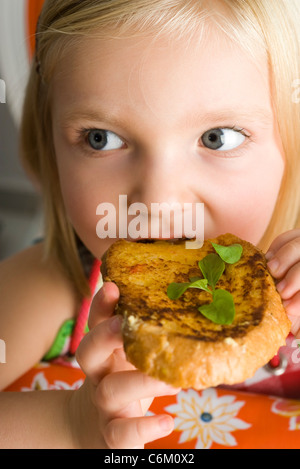 Petite fille de manger du pain grillé Banque D'Images