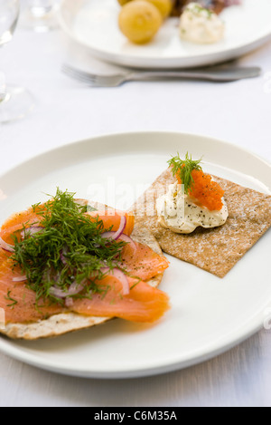 Pain croustillant garni de saumon fumé et d'aneth frais, crème fraîche et oeufs de saumon Banque D'Images