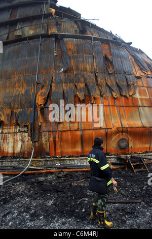 Aider les pompiers de souffle d'huile nettoyage pompiers à Dalian, Chine démarrer l'effort de nettoyage après avoir aidé à mettre une rage Banque D'Images