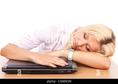 Portrait d'un épuisé young businesswoman endormie sur son ordinateur portable à son bureau Banque D'Images