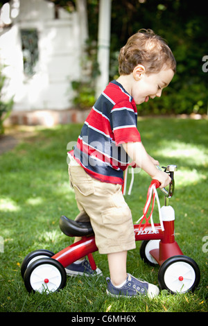 Young boy riding un tricycle Banque D'Images