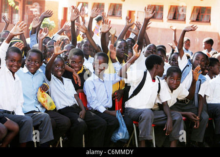 Group of young school boys dans une classe en plein air waving Banque D'Images