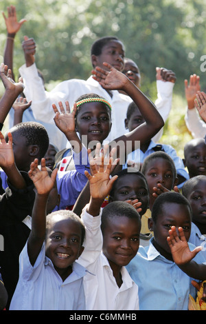 Group of young school boys dans une classe en plein air waving Banque D'Images