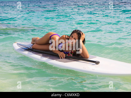 Belle brune en bikini sur son stand up paddle board à Hawaï Banque D'Images