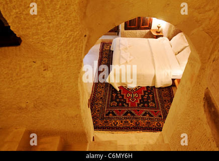 Grotte de calcaire rénové de l'intérieur de chambre à coucher design et mise en page entièrement meublé avec linge blanc et paysage, tapis tissé Banque D'Images