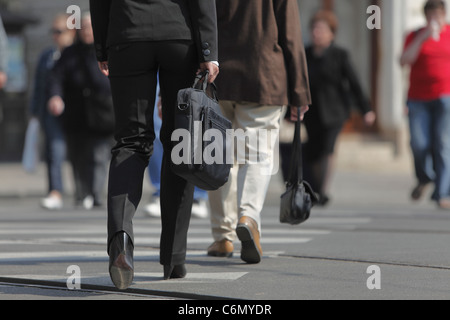Image d'une partie inférieure du corps de la femme. Il est porteur d'une sacoche d'ordinateur en traversant la rue dans une ville. Banque D'Images