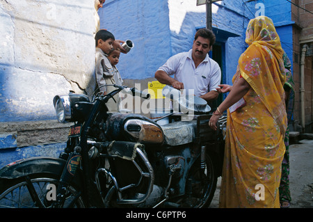 Un laitier fournit du lait sur sa moto dans les rues étroites de Jodhpur, Rajasthan, India Banque D'Images