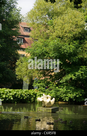 La sculpture moderne dans un étang, Adam Mickiewicz, Parc Oliwa de Gdansk, Pologne EU Occidentale Banque D'Images