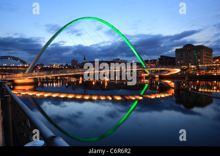 Le Gateshead Millennium Bridge prises pendant le crépuscule avec des lumières reflétées dans la rivière Tyne. Banque D'Images