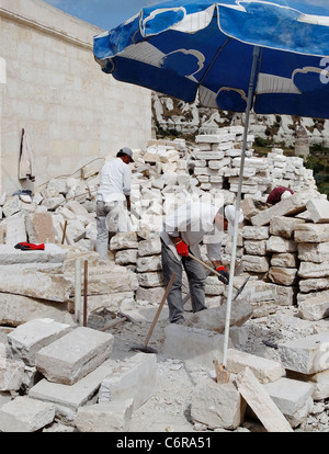 Göreme, Cappadoce, Turquie - Juin 2011 : l'homme au travail, les constructeurs turcs protégés de la chaleur du soleil par l'ombre d'un parasol Banque D'Images