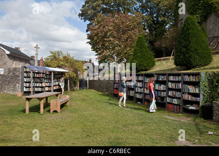 Deux personnes vous parcourez à une librairie de l'honnêteté dans le parc du château de Hay de Hay-On-Wye, UK Banque D'Images