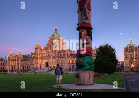 Les connaissances des Premières nations autochtones et provinciaux totem des édifices législatifs au crépuscule-Victoria, Colombie-Britannique, Canada. Banque D'Images