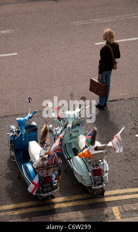 Un homme de traverser la rue à Brighton avec deux Lambrettas derrière lui Août 2011 Banque D'Images