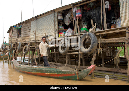 L'homme dans un bateau de shopping dans un magasin sur un affluent du lac Tonle Sap, à Kompong Klang village près de Siem Reap, Cambodge Banque D'Images