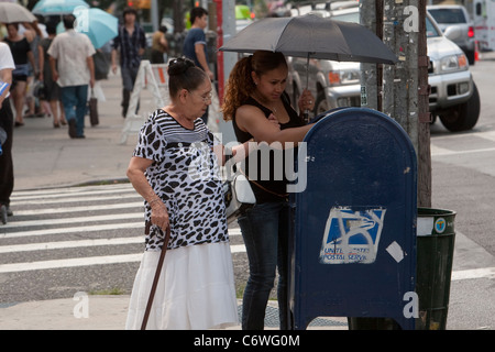 Une femme met une lettre dans une boîte aux lettres d'USPS dans le quartier de Brooklyn à New York, NY, le lundi 1er août 2011. Banque D'Images