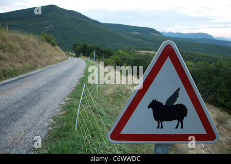 Attention, le vol à basse altitude les moutons ! Ce panneau routier français rural a été modifié par l'ajout d'ailes d'humour au mouton symbole. La Drôme, France. Banque D'Images