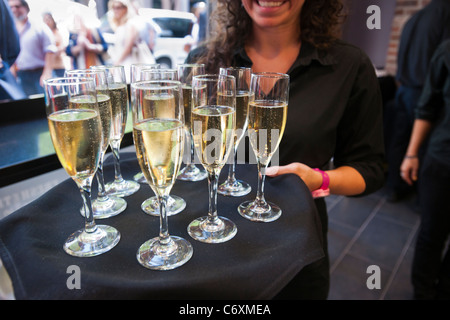 Un waitperson sert du champagne pour les clients de l'ouverture d'un restaurant à New York Banque D'Images