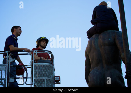 Elle : Bologne, un réfugié marocain a grimpé sur la statue de Neptune dans la Piazza Maggiore, protestant, pour le permis de résidence. Banque D'Images