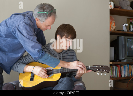 Père Fils aidant à jouer de la guitare Banque D'Images